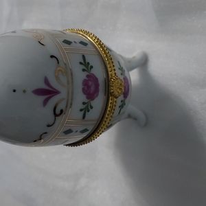 Porcelain 3 footed Egg with Roses. Pinks,green,gold. 4 inchesHxover 2 inches W.